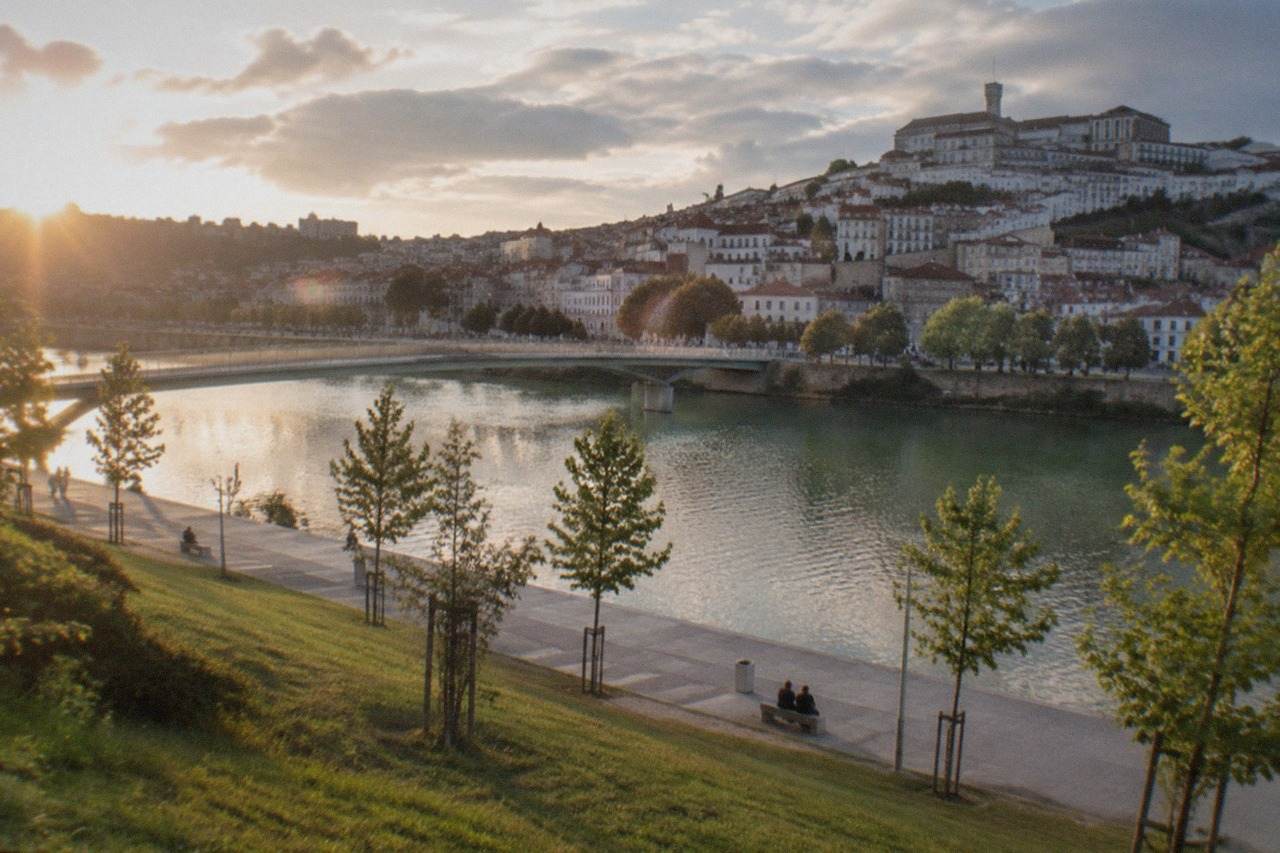 The historic buildings of Coimbra university rising above the River Mondego in Portugal