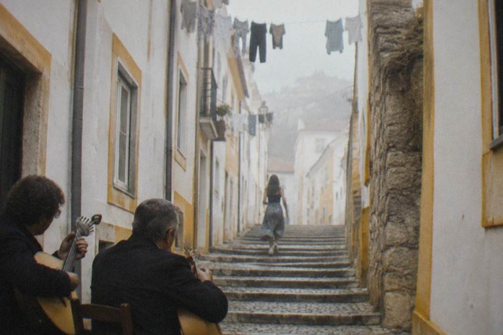 Two musicians playing Portuguese guitars in a Coimbra fado performance