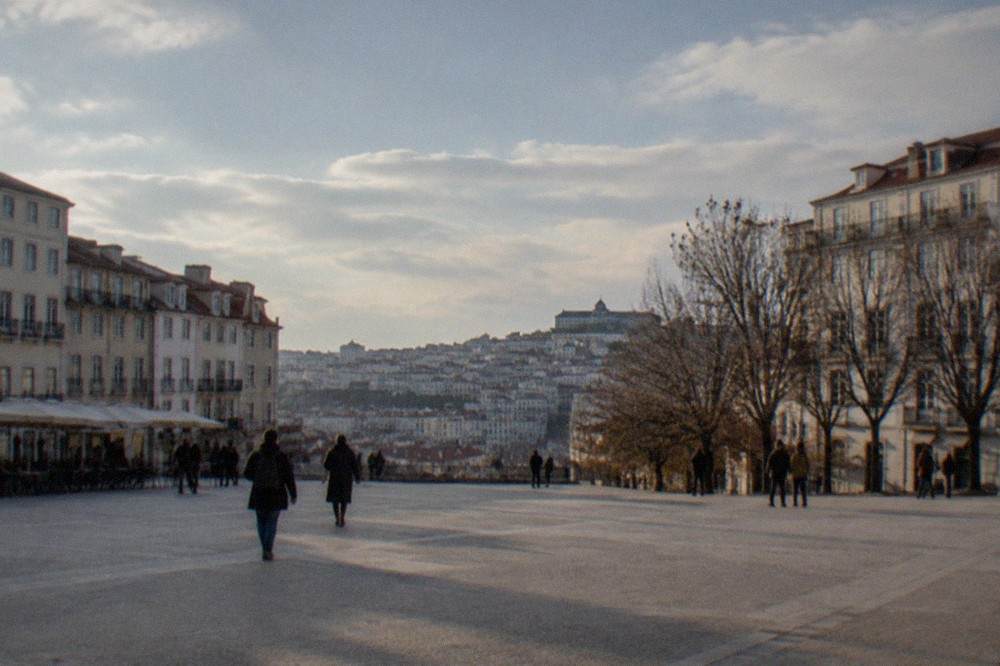 Visitors walking through the narrow cobbled streets of Coimbra's old town below the university hill