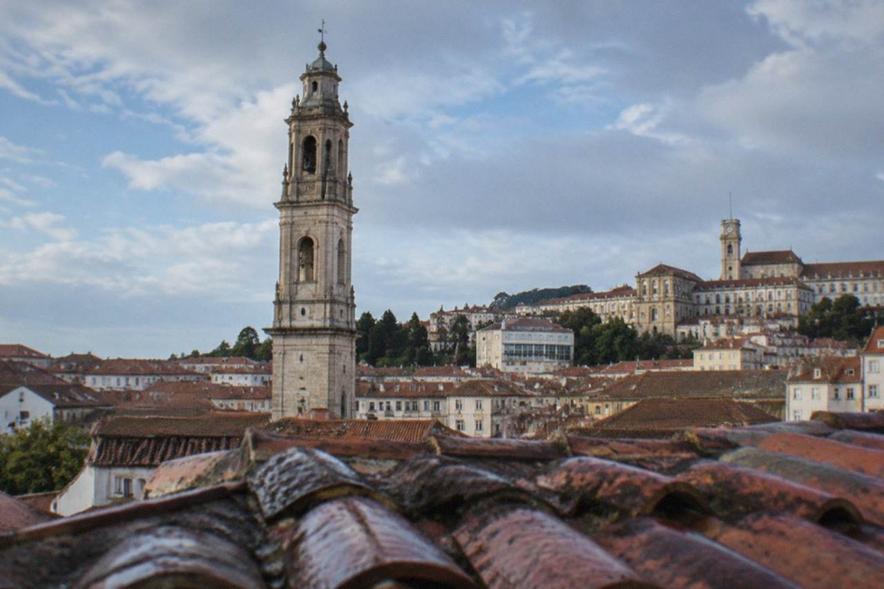 The University of Coimbra buildings and clock tower seen from the old town rooftops