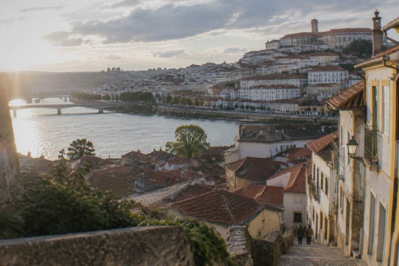 View over the rooftops and river of Coimbra, Portugal, with the old university buildings on the hill above the city