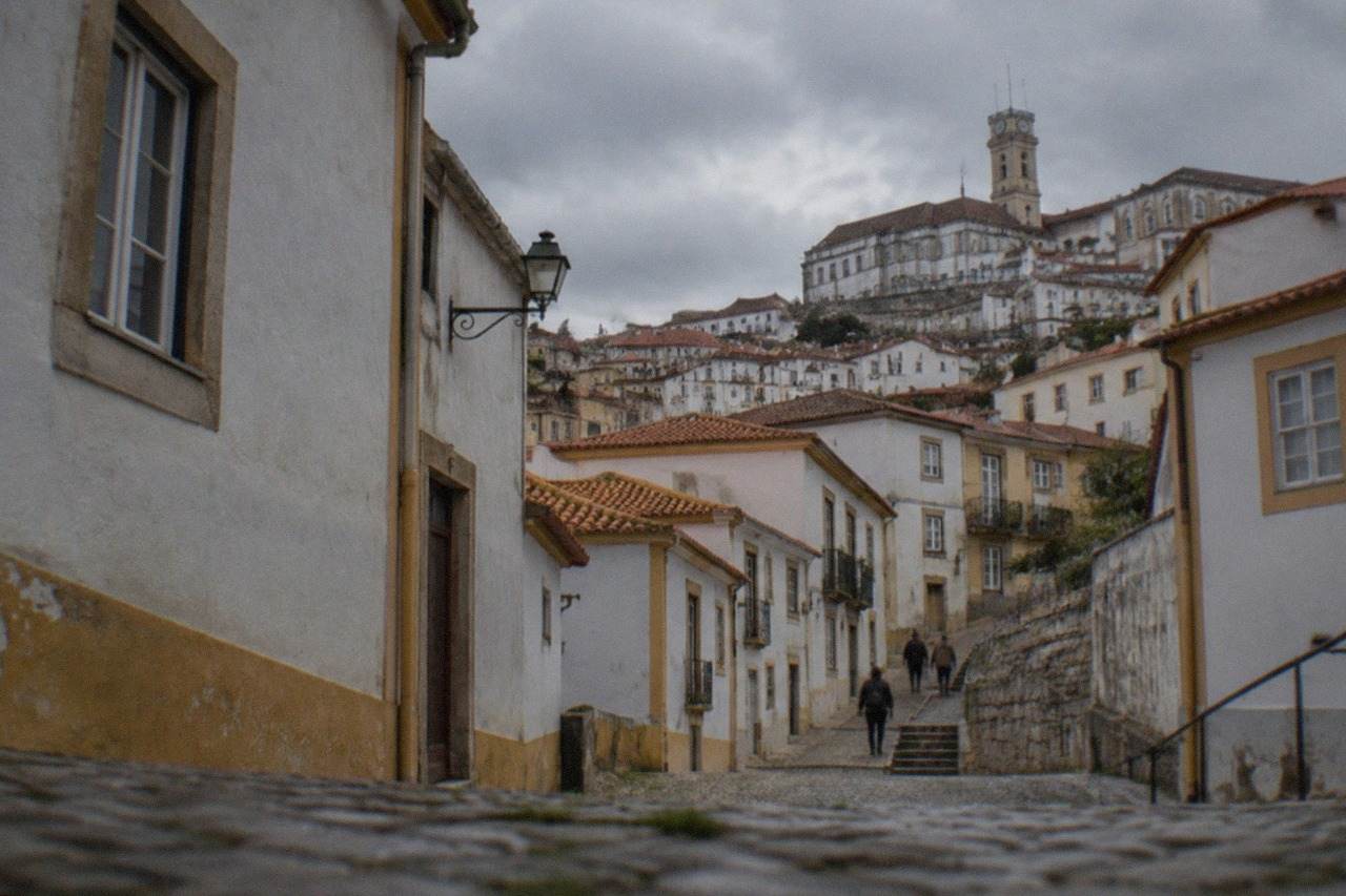Cobbled street climbing toward the university buildings of Coimbra, Portugal