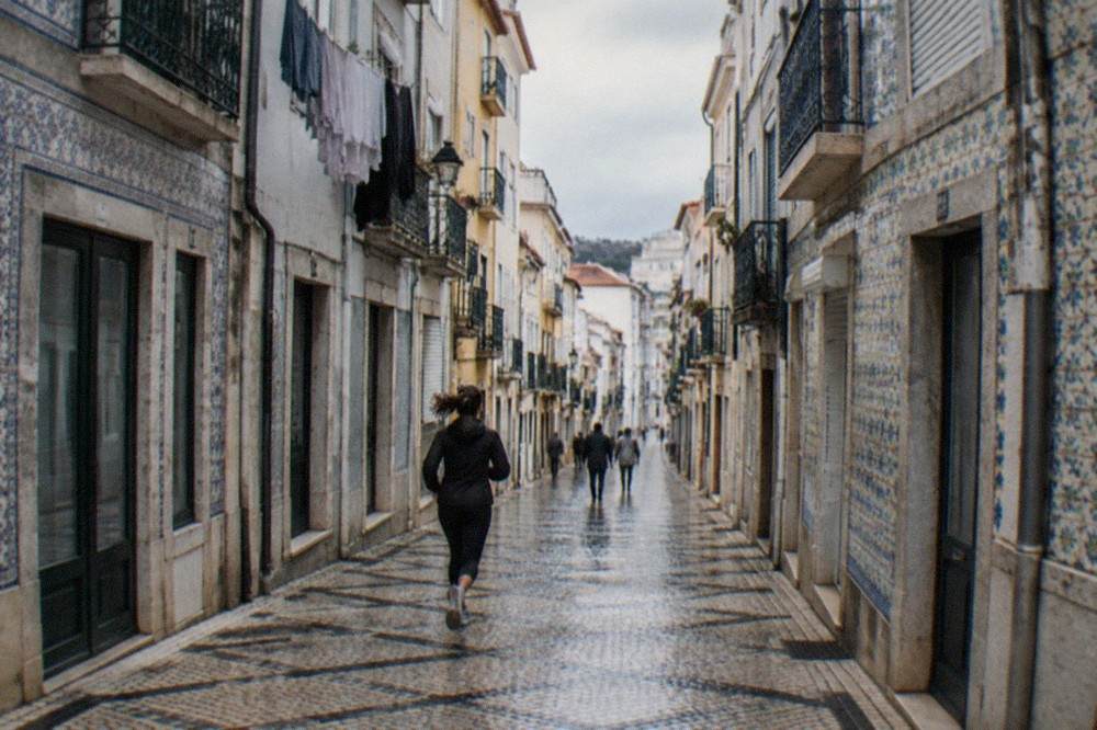 A quiet street of old buildings on the lower town of Coimbra with laundry and tiled facades in morning light