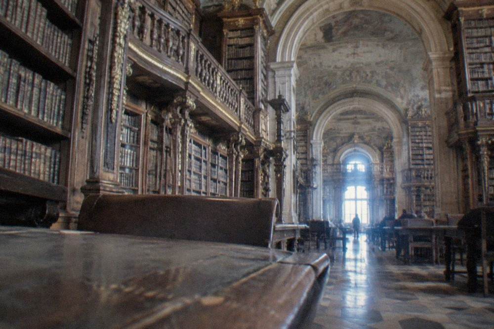 A visitor's view of the gilded upper gallery and carved wooden bookcases inside the Joanina Library's reading room
