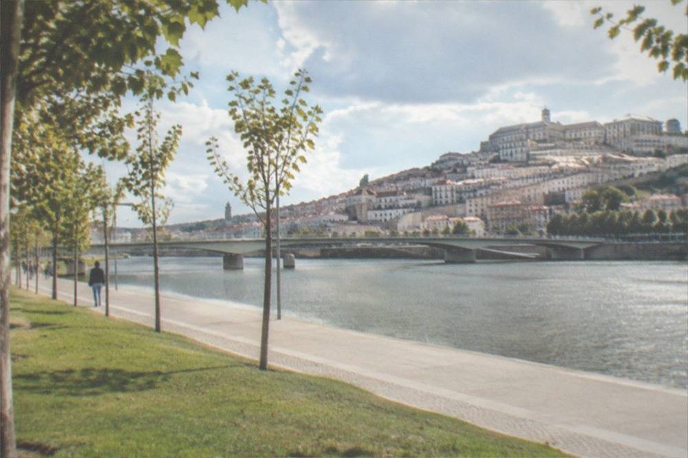 The Mondego riverfront of Coimbra with the lower town buildings along the bank