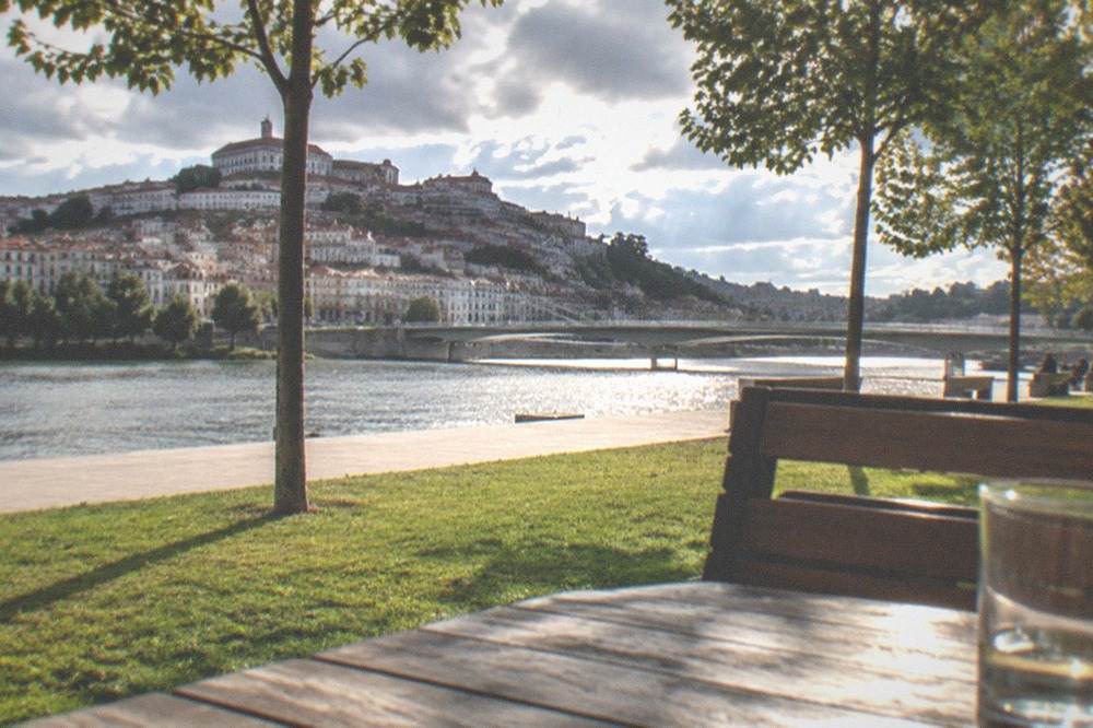 Sunlit terrace overlooking the Mondego river and the lower town from the university hill in Coimbra