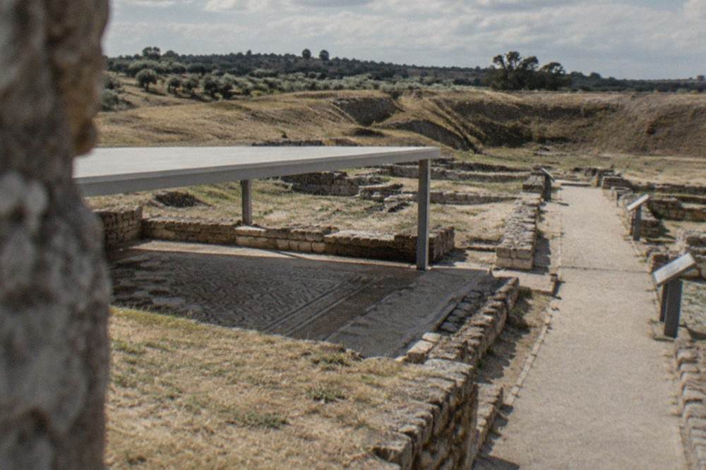 Walkway leading through excavated Roman wall fragments with information panels alongside