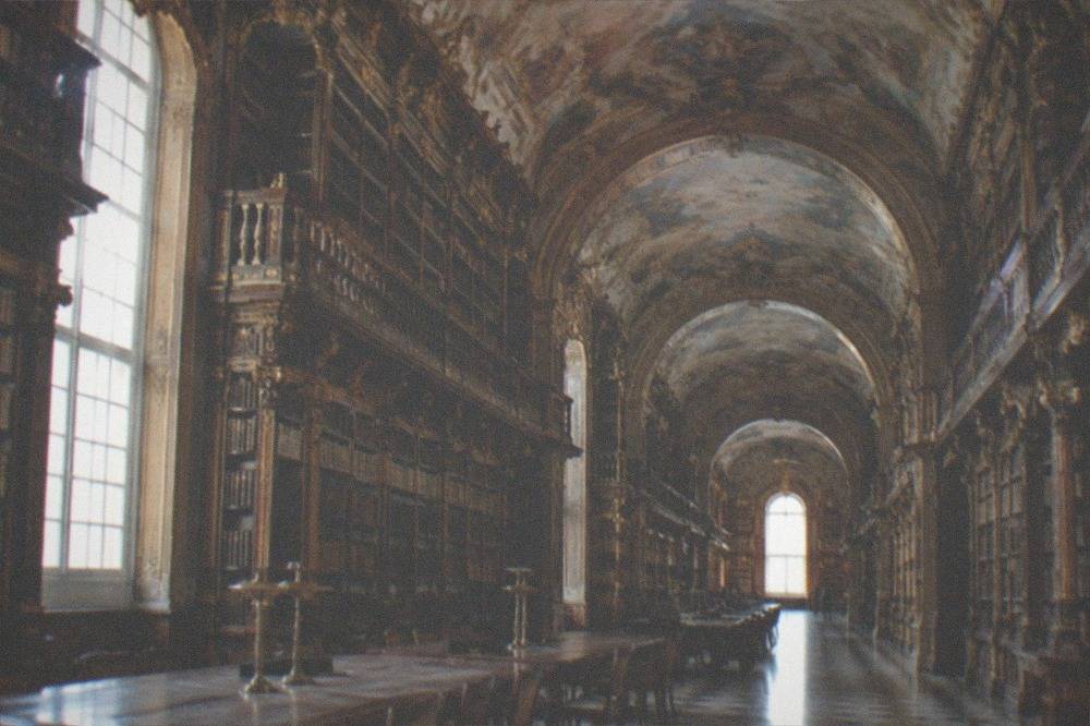 Painted ceiling and gilded bookshelves in one of the Joanina Library rooms in Coimbra