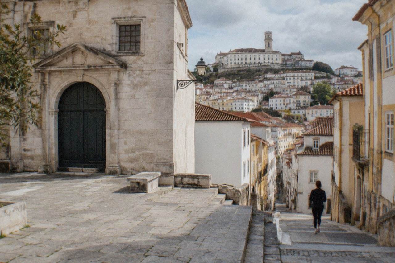 The stone facade of a museum building on a small square in Coimbra with closed entrance doors