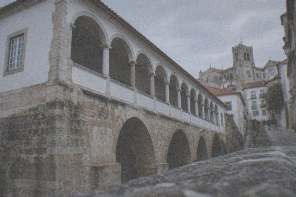 A steep narrow street of old stone buildings climbing toward a cathedral tower