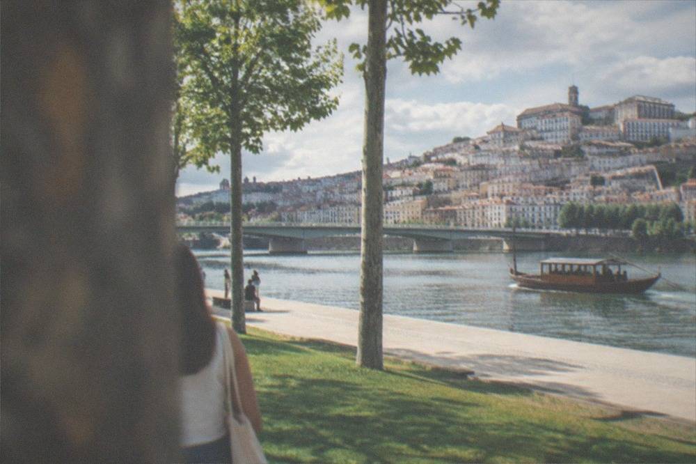 Traditional wooden river boat on the Mondego with Coimbra's old town behind it
