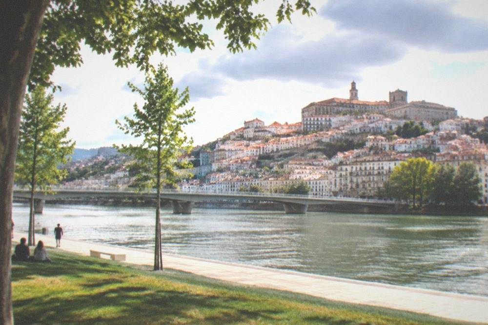 View across the River Mondego toward the old town skyline with cathedral towers