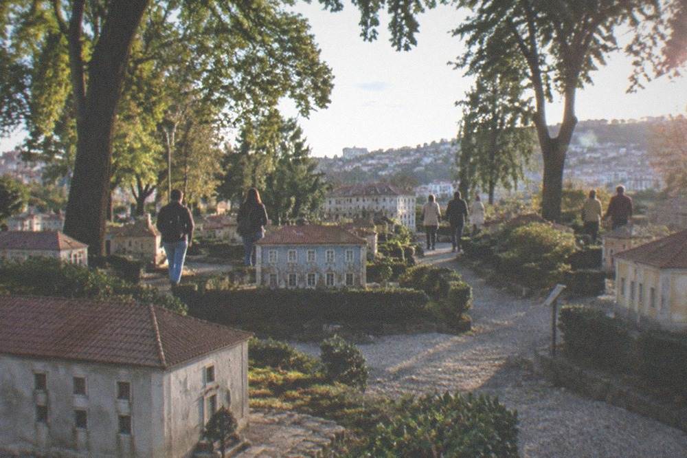 A wide view of the miniature park with visitors walking between small buildings