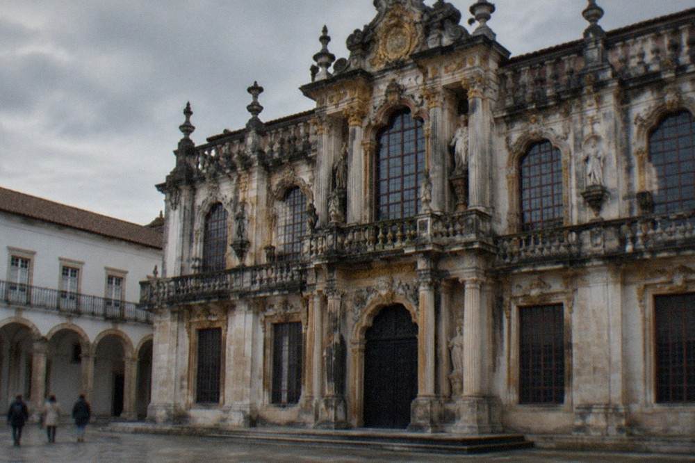 The grand baroque facade of the Joanina Library at the University of Coimbra seen from the university courtyard
