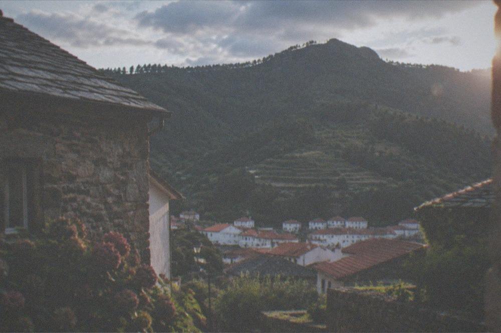 Stone houses with slate roofs overlooking a valley of green forest
