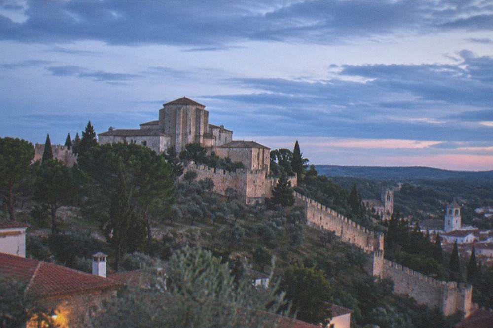 Evening light over a Portuguese hilltop town with church towers and terracotta roofs