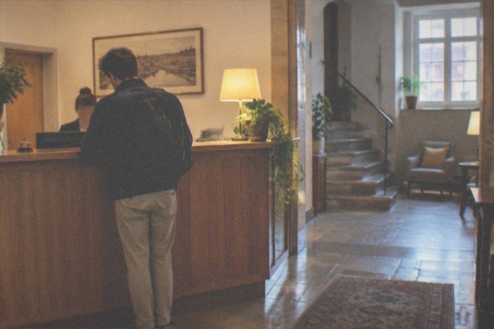 A reception desk in a small Portuguese hotel with a guest checking in