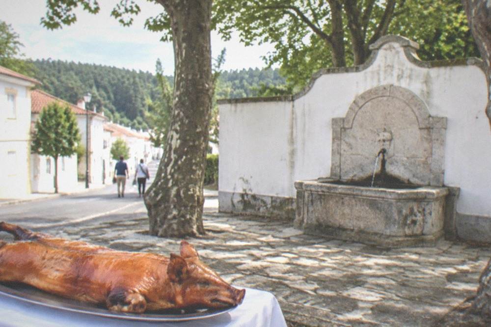 A whole roast suckling pig with crisp golden skin on a platter