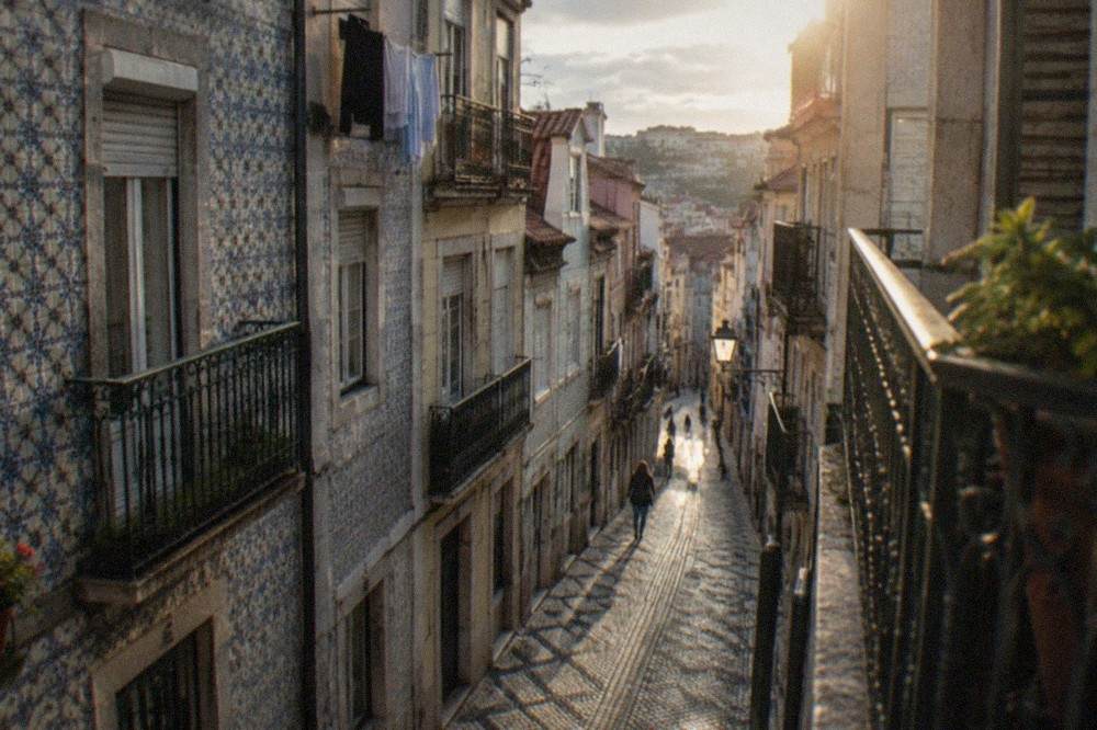 Narrow cobblestone street in the Baixa low town of Coimbra with hotel facades and hanging laundry