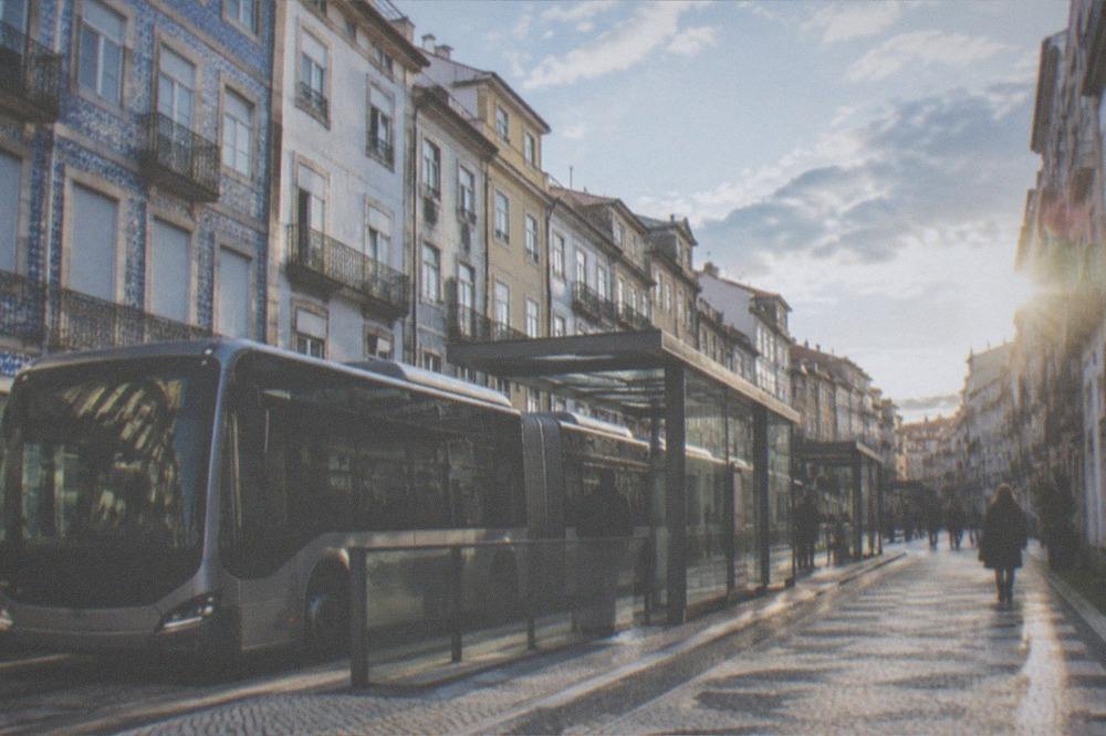 A modern articulated bus rapid transit vehicle at a station platform in a Portuguese city