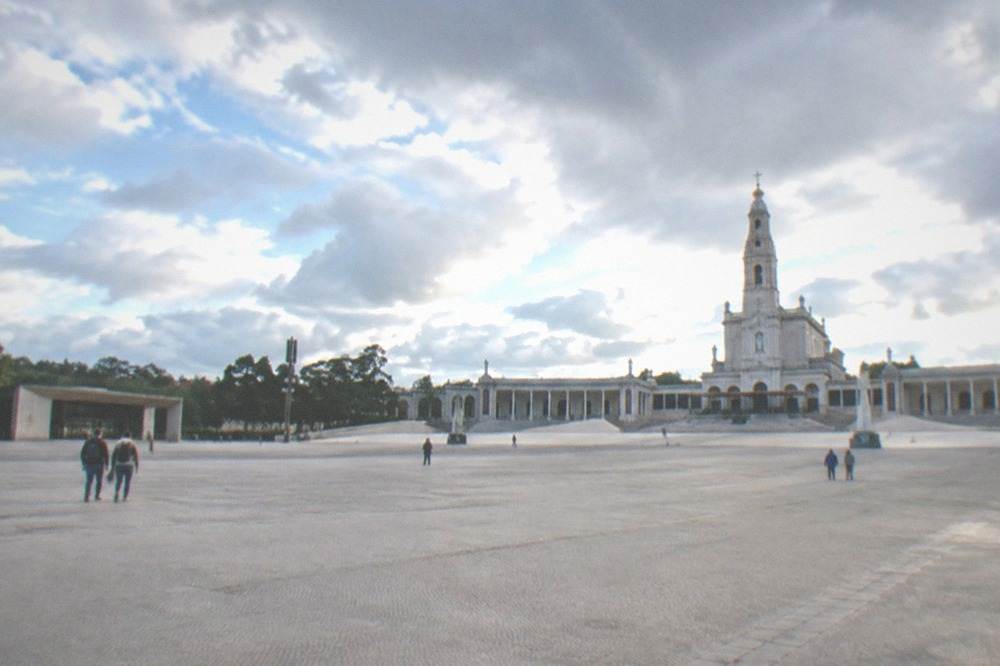 Pilgrims walking the large open esplanade at the Fátima sanctuary