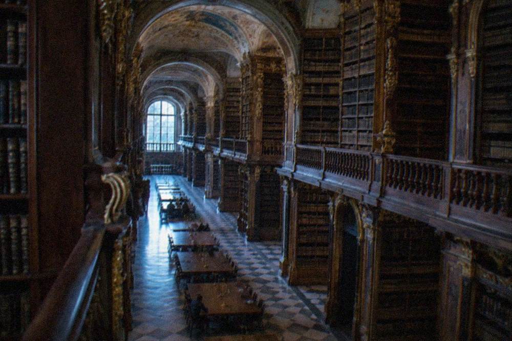 The ornate baroque interior of the Joanina Library with tall wooden bookshelves