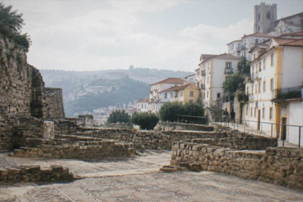 Roman mosaic floors and stone walls of an excavated ancient town under open sky