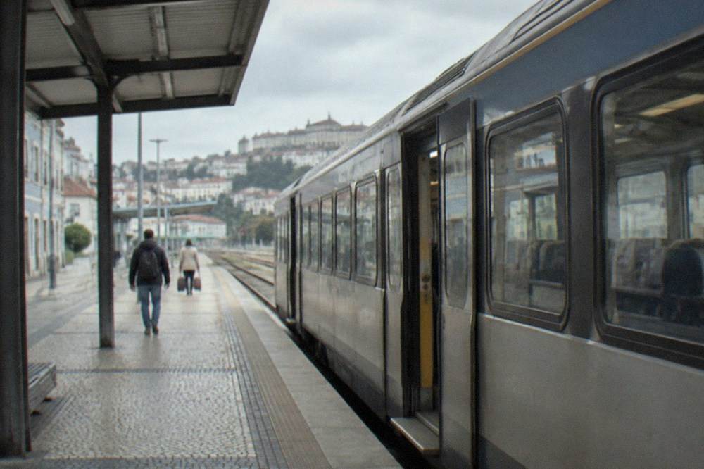 A train platform at a Portuguese railway station with a regional train waiting