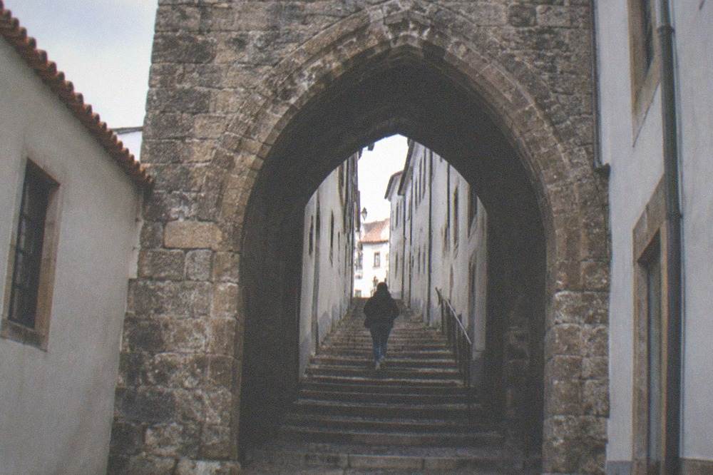 The gate of the Arco de Almedina on a steep lane in Coimbra's old town