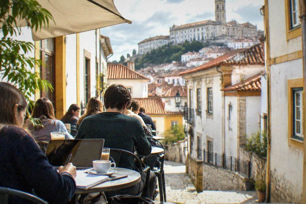 Students studying over coffee at small tables in a crowded Coimbra café