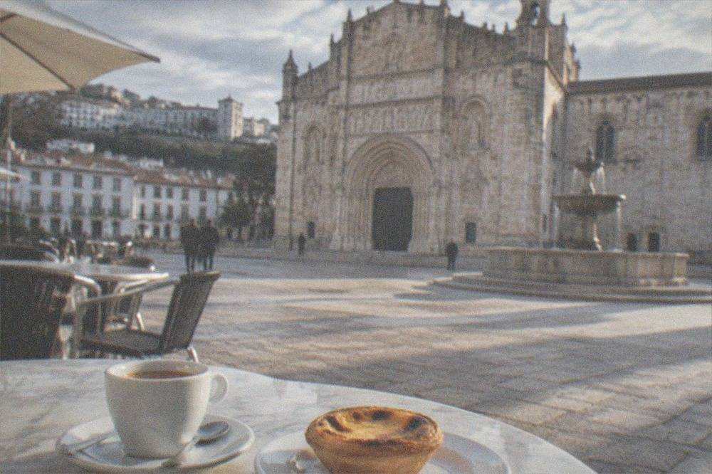 Close-up of a small espresso cup and a sweet pastry on a marble café table
