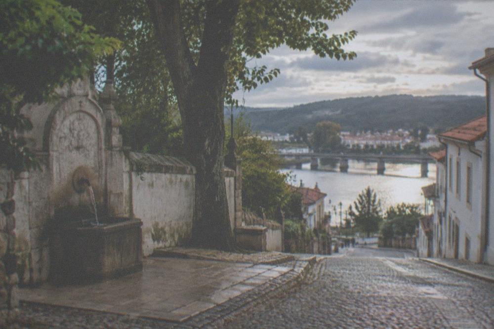 A stone street in Coimbra's old town leading down towards the River Mondego