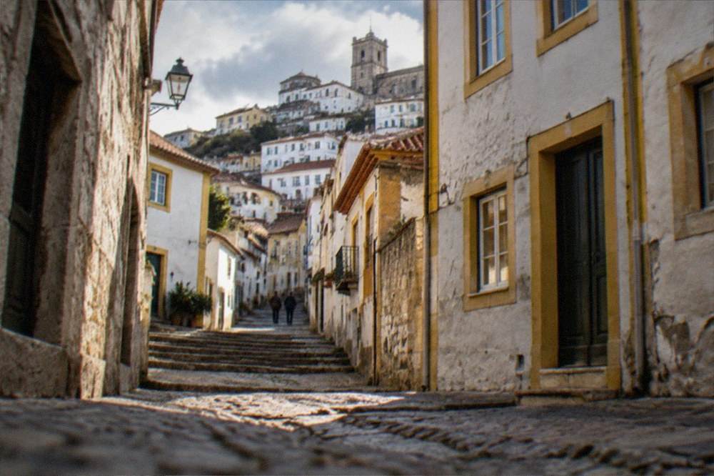 A narrow cobbled street climbing steeply between old stone buildings