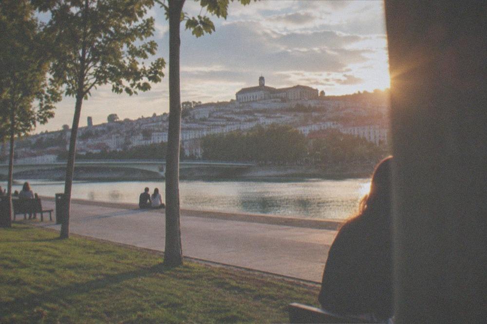 Warm evening light over the rooftops of Coimbra with the Mondego river in the distance
