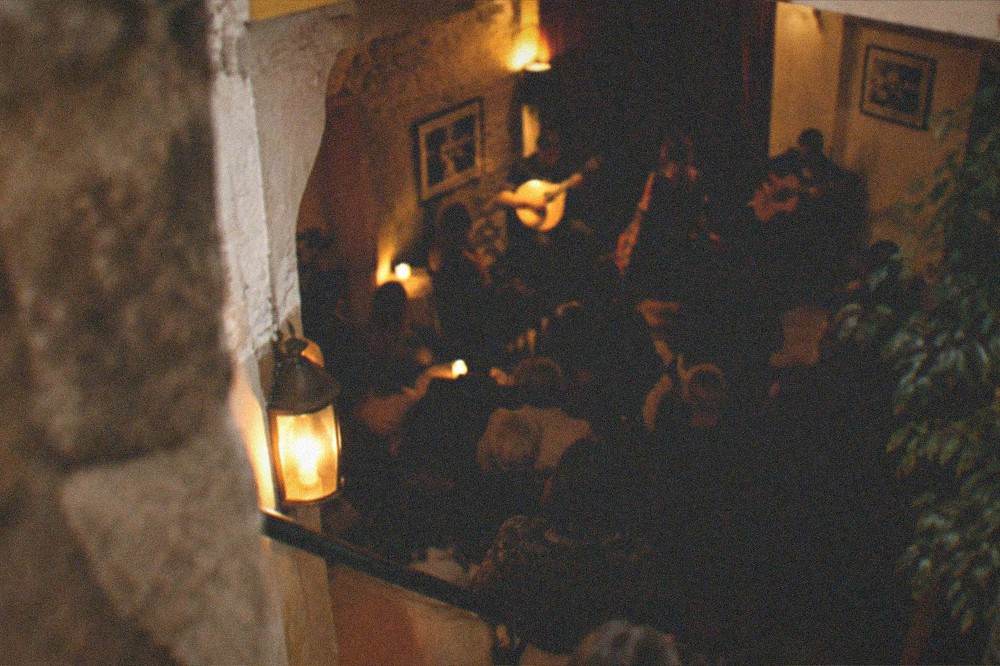 Evening view of a fado performance room in Coimbra with guitars and dim lighting