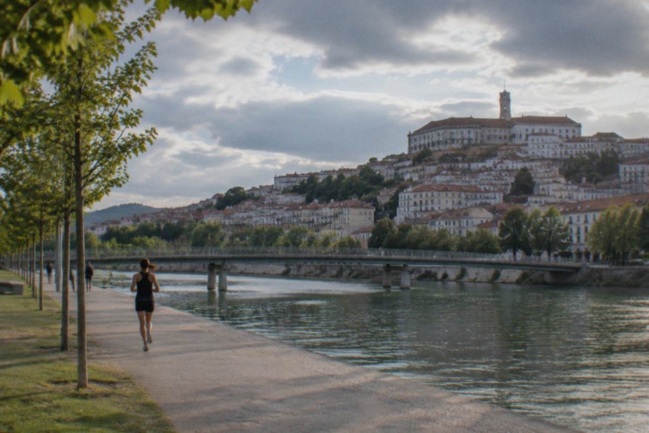 The old town of Coimbra rising above the River Mondego, with the university tower visible at the top of the hill
