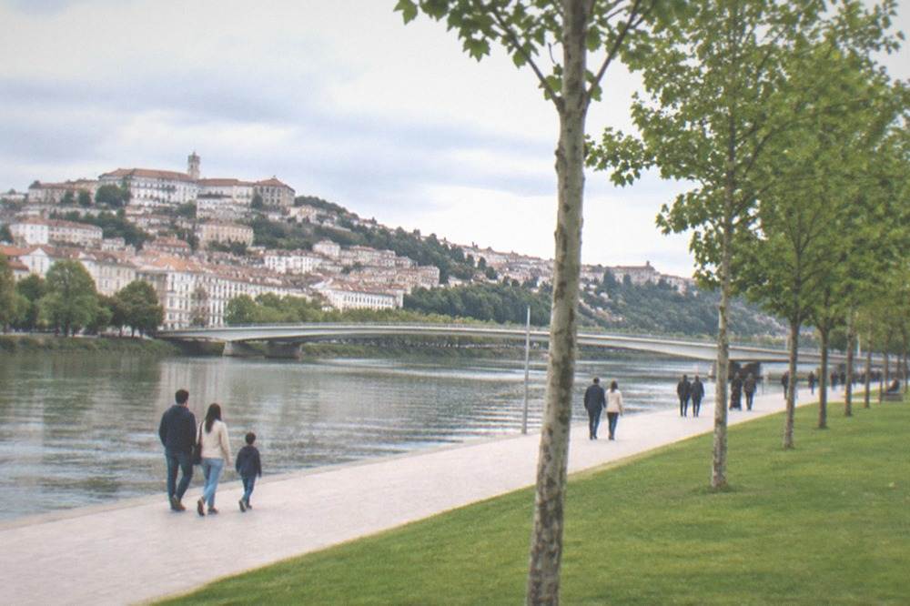 Families and visitors walking along the riverfront park beside the Mondego in Coimbra