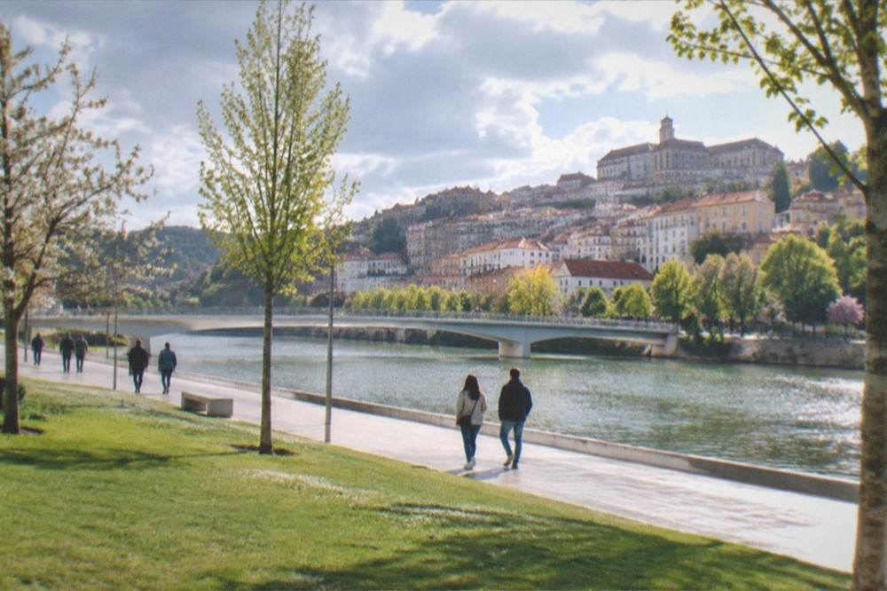 Spring sunshine on the Mondego riverside park in Coimbra with people strolling