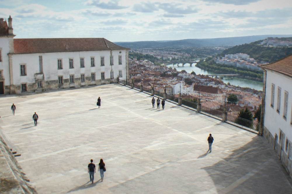 The wide stone court of the Paco das Escolas with the university buildings on three sides and the city below