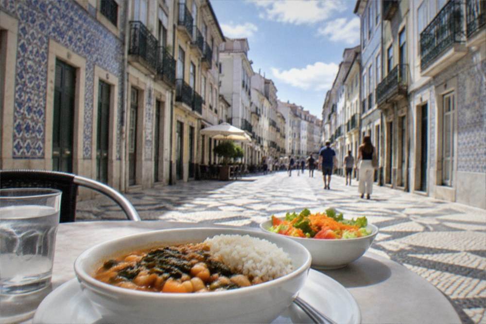 A bowl of bean and vegetable stew with rice and salad on a café table