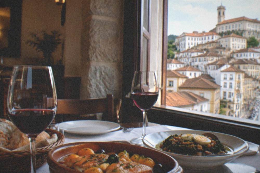 An evening table with wine glasses and regional Portuguese dishes in a Coimbra dining room