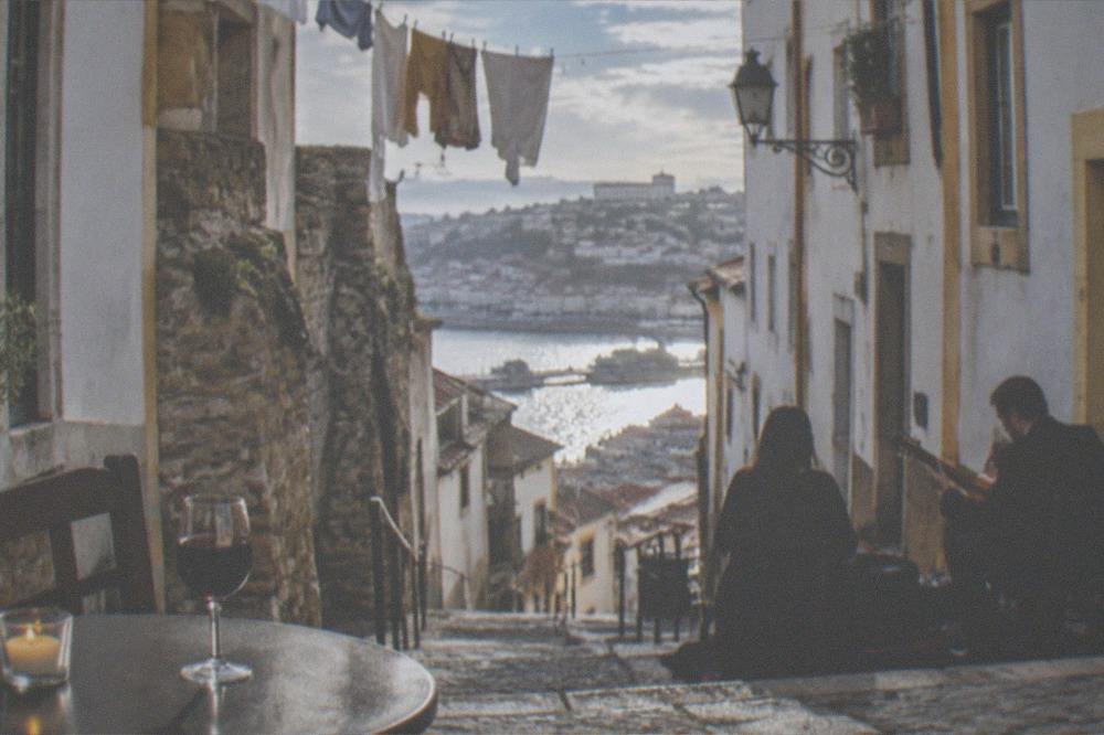 A glass of port wine on a small table beside a candle before a fado performance