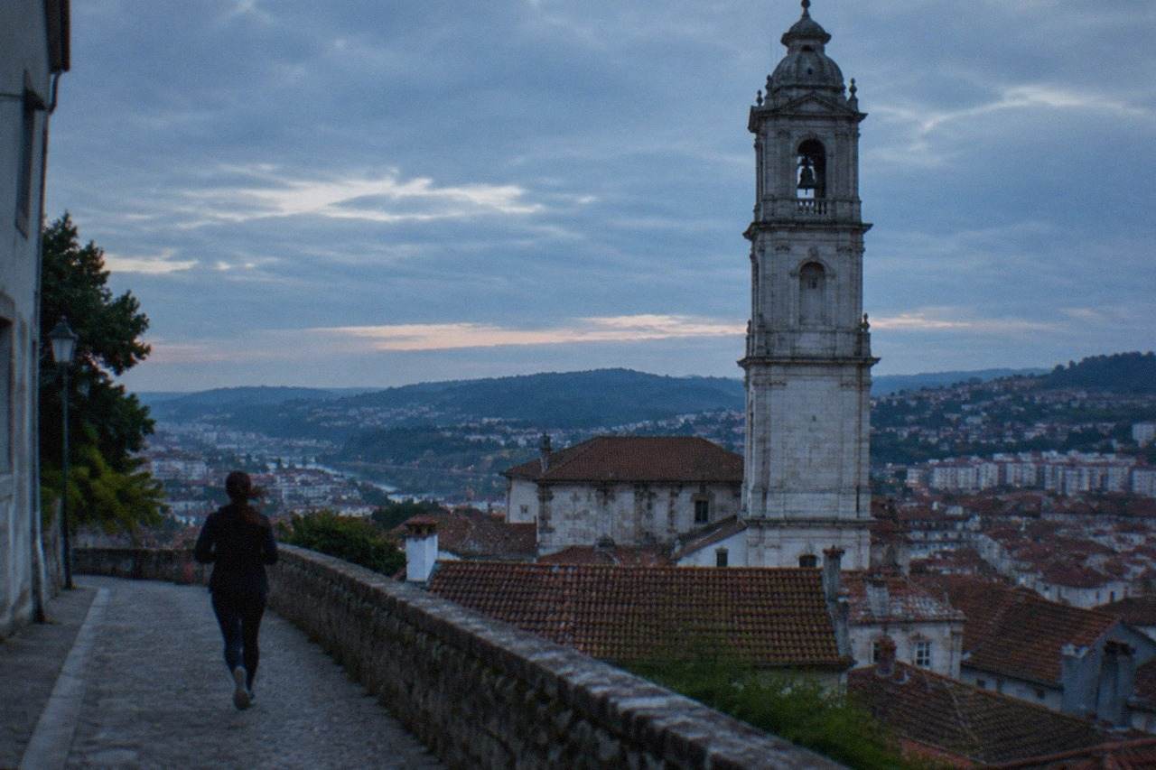 View over the tiled rooftops of Coimbra with the university tower rising above the old town