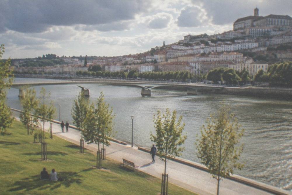 Riverside path along the Mondego with the old town of Coimbra on the opposite bank