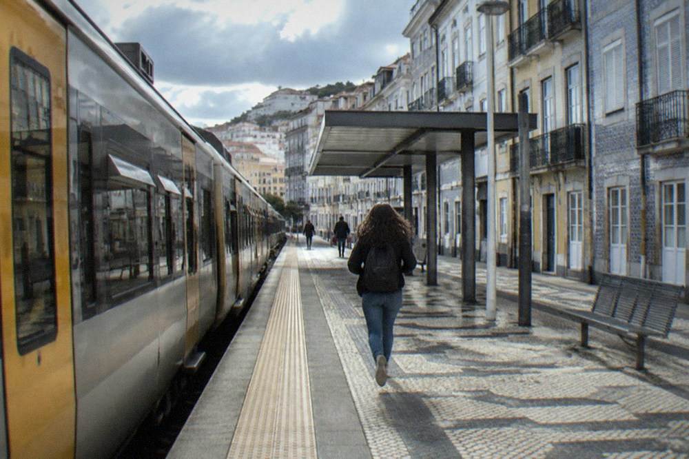 A regional train standing at a Portuguese station platform in morning light