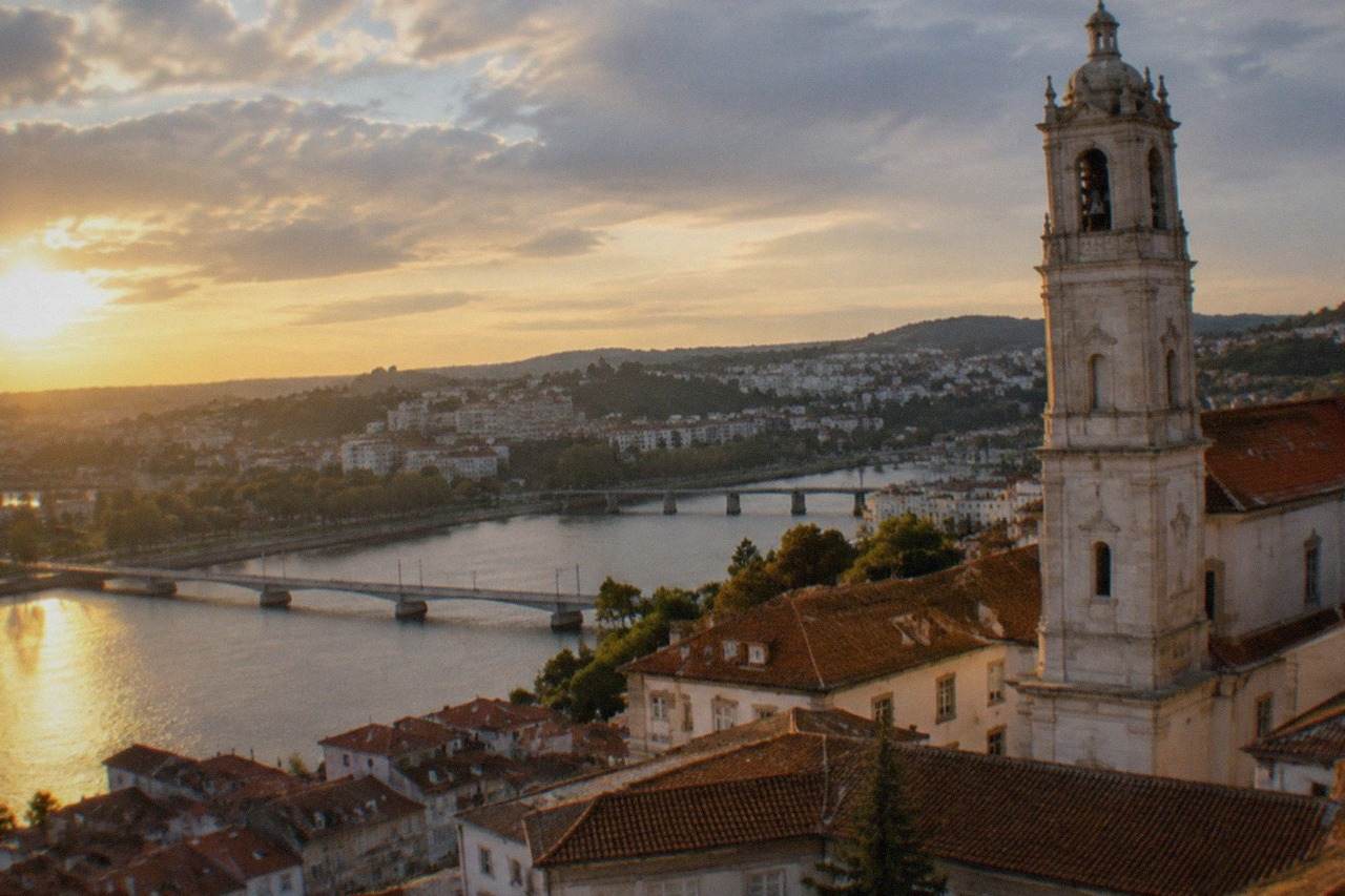 View over the tiled roofs of Coimbra old town with the university tower rising above the River Mondego