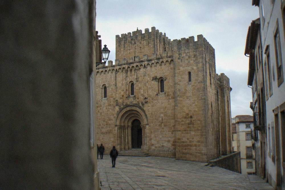 The Romanesque exterior of the old cathedral of Coimbra in late afternoon light.