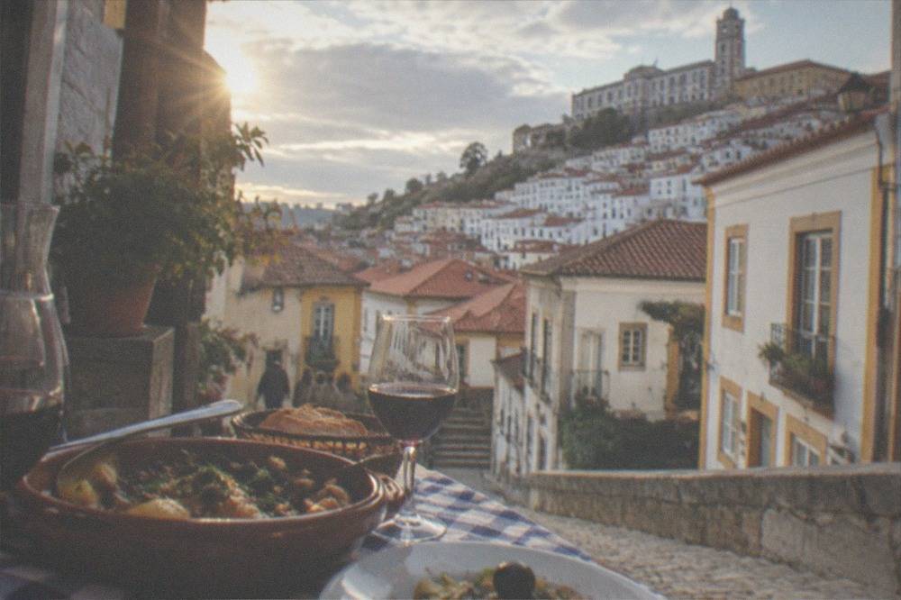 A table with regional Portuguese dishes and wine in a small Coimbra restaurant